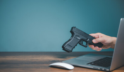 Buying handgun from online seller shop, Hands of seller sending handgun on computer to buying handgun person on website or social media with copy space. - 540627809