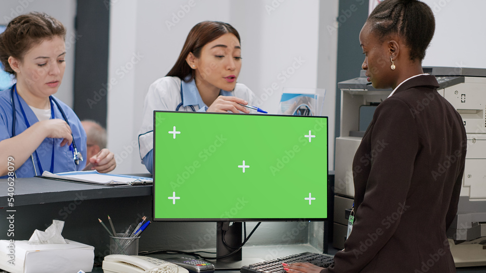 Poster diverse medical staff working with greenscreen on computer at hospital reception counter. using isol