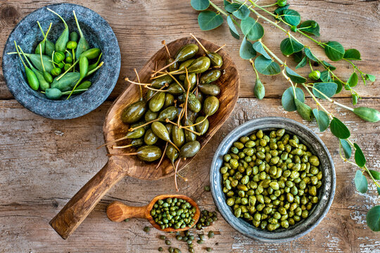 Capers in spoon and bowl on the table