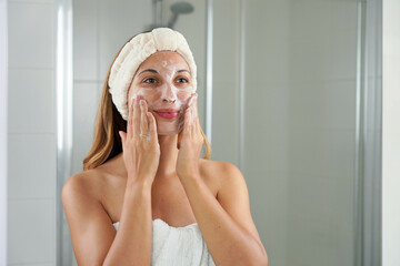 Skincare woman washing face foaming soap scrubbing skin. Face wash exfoliation scrub soap woman...