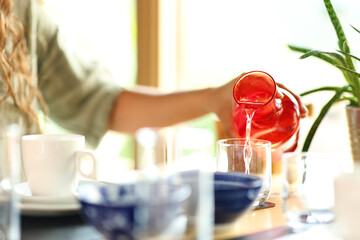 Woman hand filling glass with water in a restaurant