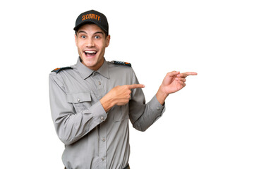 Young security man over isolated background surprised and pointing side