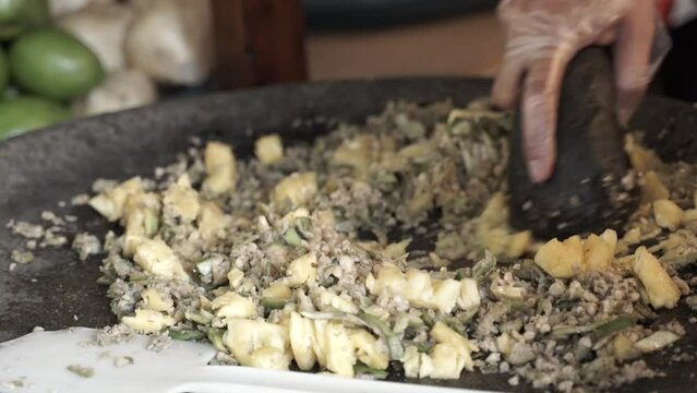 The process of mashing rujak fruit salad or rujak duck