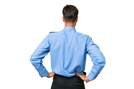 Young police man over isolated background in back position