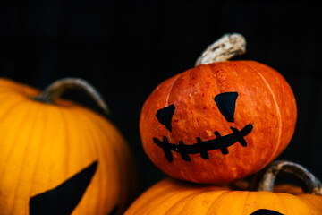 Close up portrait of bright orange  jack-o-lantern pumpkin face with black eyes and mouth as concept of Halloween