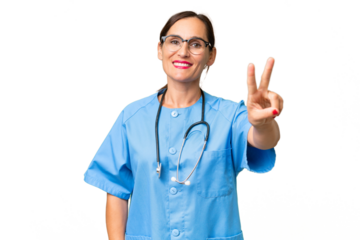 Middle-aged nurse woman over isolated background smiling and showing victory sign
