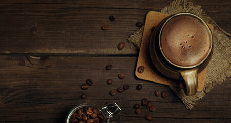 Obraz na płótnie Canvas Ceramic cup with coffee and coffee beans on a dark background