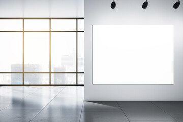 Big blank white illuminated billboard with place for your advertisement on light wall in sunlit empty hall with grey floor and city skyscrapers view from panoramic window. 3D rendering, mockup