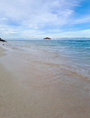 Tropical beach in the Derawan. Beautiful sandy beach and soft blue ocean wave