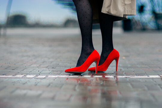 Fashionable red women's shoes on a high thin heel with fashionable black tights.