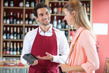 salesman offering wine bottle opener to woman