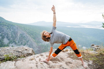 Triangle pose in yoga guy pulls his hand up, man performs asana on body balance, meditation in the...