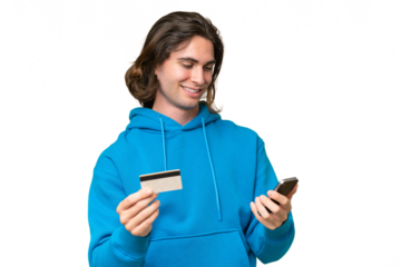 Young handsome man isolated on green chroma background buying with the mobile with a credit card