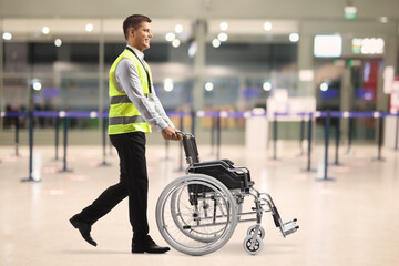 Airport employee pushing an empty wheelchair