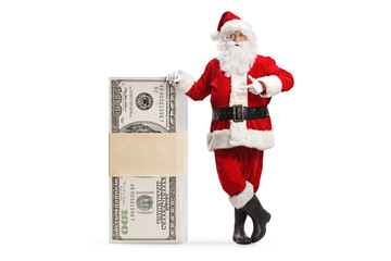 Santa claus leaning on a stack of money and pointing