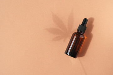 Amber glass dropper bottles with cannabis oil used for medical purposes on beige background....