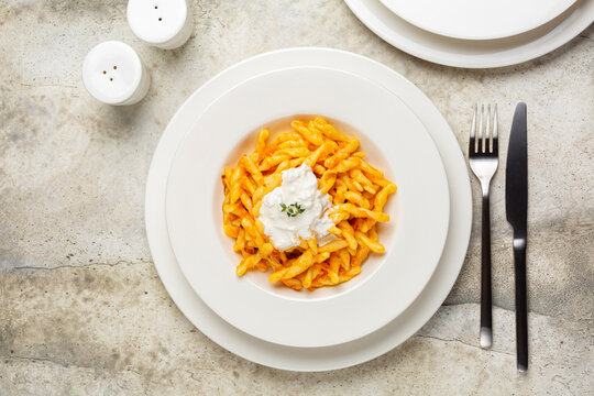 Pasta strozzapreti with stracciatella cheese and butternut pumpkin sauce with thyme. Top view.