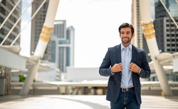 The Portrait Of Happy Young Handsome Caucasian Businessman With Eyeglasses And Wearing Deep Blue Suits For Professional Look.