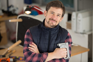 male upholsterer holding a staple gun