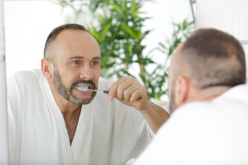 Fototapeta premium a man is brushing teeth