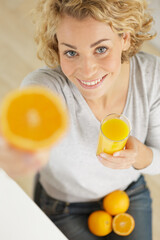 picture of woman holding sliced orange and juice