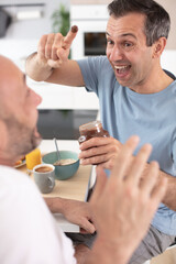 happy gay couple having breakfast and fun together
