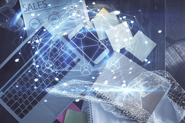 Social network hologram drawings over computer on the desktop background. Top view. Double exposure.