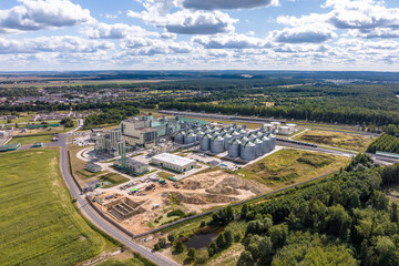 Obraz premium aerial view on rows of agro silos granary elevator with seeds cleaning line on huge agro-processing manufacturing plant for processing drying cleaning and storage of agricultural products