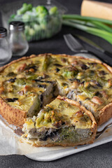 Quiche with chicken, mushrooms, broccoli and cheese, homemade traditional french pie with a cut piece, Vertical image