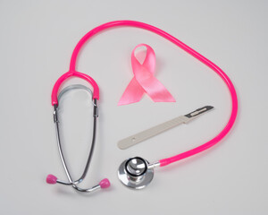  Pink stethophonendoscope, satin ribbon and scalpel on white background. 