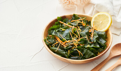 close up salad laminaria Kelp or wakame seaweed salad in wood bowl on white table background with copy space. salad laminaria Kelp or wakame seaweed salad food
