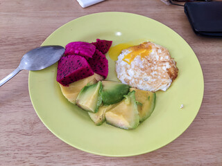 pieces of dragon fruit, avocado pieces, and fried eggs. healthy breakfast in the morning.