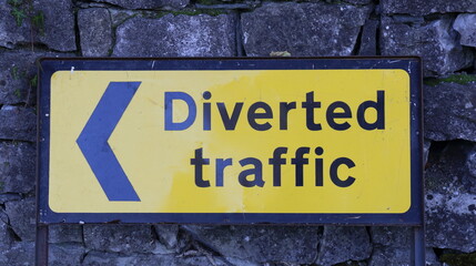 Road Sign for Diverted Traffic with arrowhead. Black lettering on yellow background.