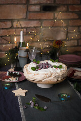 Christmas cake Pavlova with cranberries decorated with on dark blue background