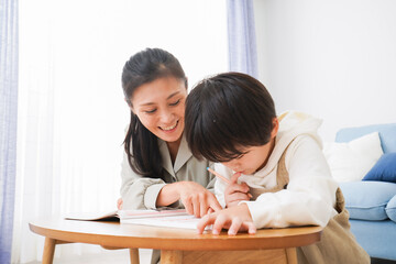 家でお母さんと一緒に勉強をする男の子