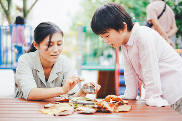 葉っぱで遊ぶお母さんと息子