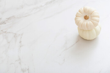 white pumpkins on white marble background