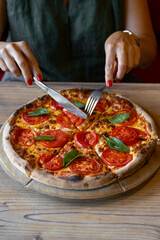 close-up shot of woman eating delicious pizza with cutlery