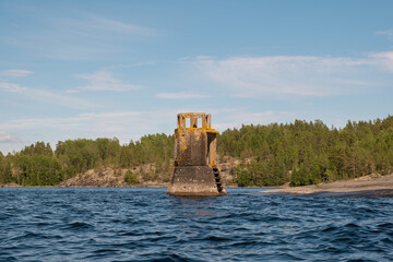 Naklejka premium Karelia. Rocky shore with an abandoned lighthouse. Rusty building. Ladoga lake. Skerries
