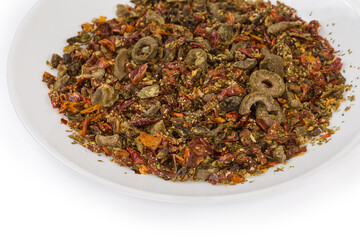 Mixture of different dried vegetables and spices on white dish