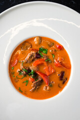 Asian Tom Yam soup with shrimps, coconut milk, tomatoes, lemongrass, mint and cilantro