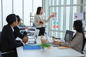 Asian business people meeting and talking in the room, businesswoman present in font of the board with discussion and participation