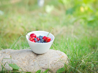 A set of summer fruits in a bowl.