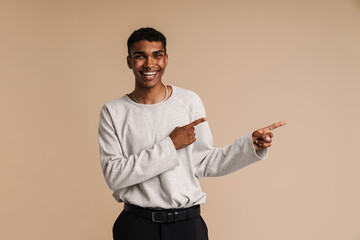 Young black man with piercing laughing while pointing fingers aside