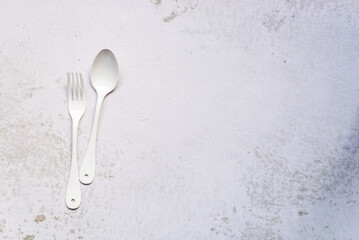 white cutlery set, a pair of fork and spoon on marble background