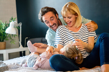 Young family being playful at home. People parent child fun happiness concept.