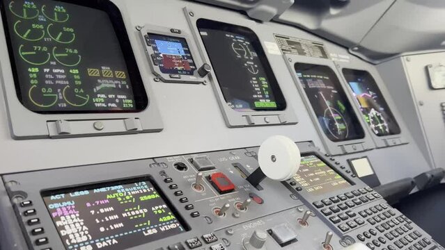 Close view of a jet cockpit while copilots selects landing gear lever down. Daylight.