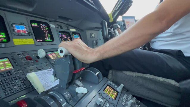 Close view of jet flight controls and engine throttles while copilot is landing. Daylight. 4k