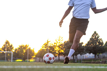 Player feet with the ball scoring a goal. Football player on the field running with the ball....