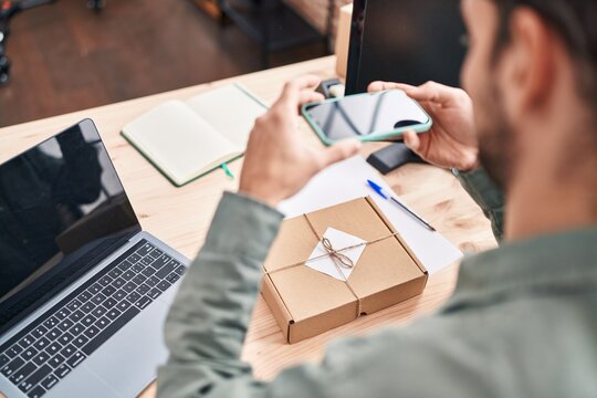 Young man ecommerce business worker make photo to package at office